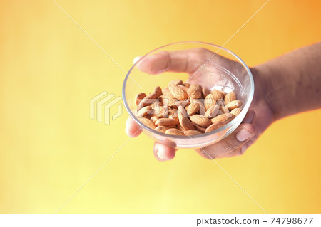 close up person hand holding a bowl on almond close up person hand holding a bowl on almond 74798677