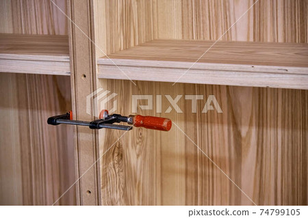 Ash veneered mdf bookcase in workshop. Wooden furniture closeup Ash veneered mdf bookcase in workshop. Wooden furniture closeup 74799105