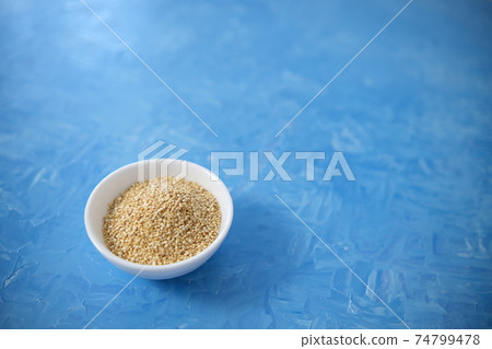 Quinoa is an organic food for healthy eating. In a round bowl. The blue background is painted with oil paints. 74799478