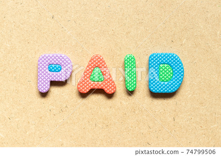 Foam alphabet letter in word paid on wood background 74799506