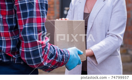 Courier brings parcel to the recipient's house, woman picks it up Courier brings parcel to the recipient's house, woman picks it up 74799937