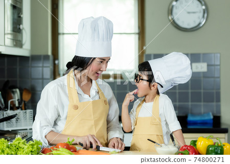 Cooking Family. Chef kid boy and mother making and leaning fresh vegetables salad for healthy eat 74800271