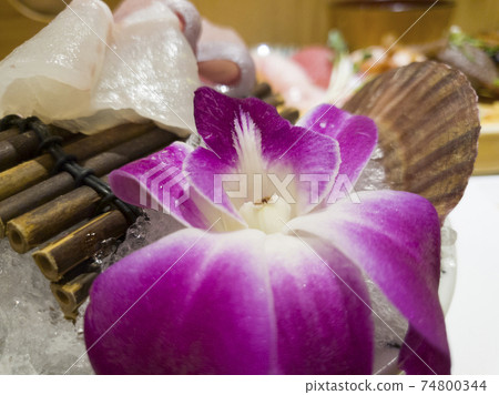A single flower petal and fresh raw fish A single flower petal and fresh raw fish 74800344