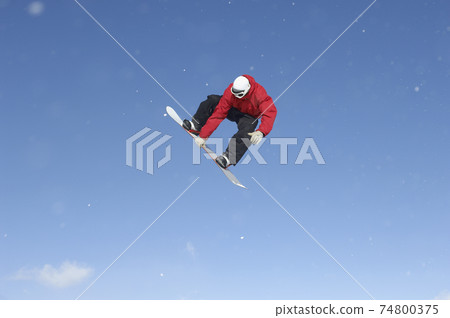 Snowboard Free Rider Making High Jump Against Blue Sky 74800375