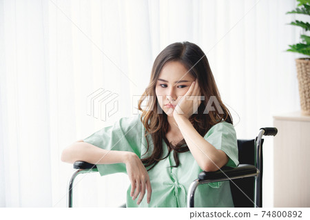 Sad and depressed asian woman in a wheelchair . Copy space on the window. Sad and depressed asian woman in a wheelchair . Copy space on the window. 74800892