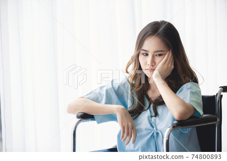 Sad and depressed asian woman in a wheelchair . Copy space on the window. Sad and depressed asian woman in a wheelchair . Copy space on the window. 74800893