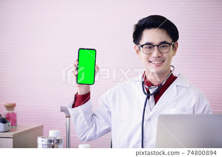 Young doctor showing a phone with smile face in office. Young doctor showing a phone with smile face in office. 74800894