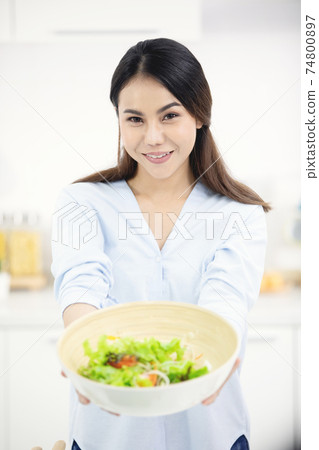 Young asian woman making food in the kitchen. 74800897