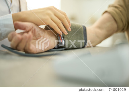 Fragment photo of doctor setting up manometer for examining patient 74801029
