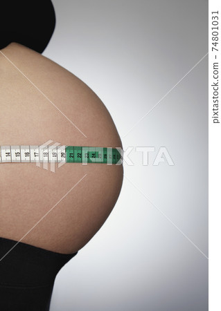 Pregnant Woman Measuring Abdomen With Tape Measure Pregnant Woman Measuring Abdomen With Tape Measure 74801031