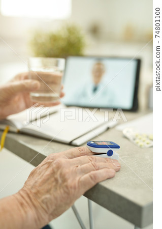 Senior citizen measuring vitals and consulting doctor online from home 74801100