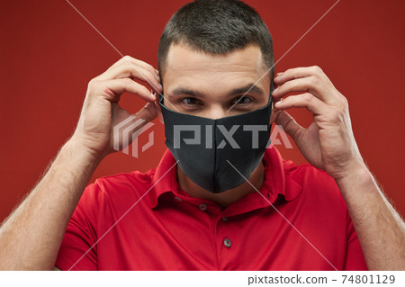 Strong ,ale in sportswear looking at the camera in the indoors 74801129