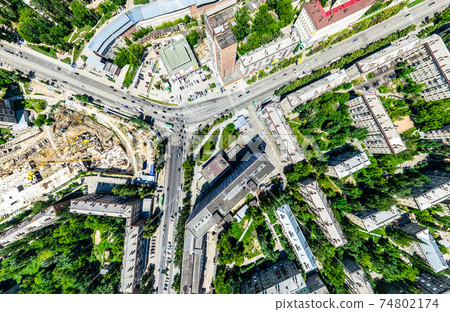 Aerial city view with crossroads and roads, houses, buildings, parks and parking lots. Sunny summer panoramic image Aerial city view with crossroads and roads, houses, buildings, parks and parking lots. Sunny summer panoramic image 74802174