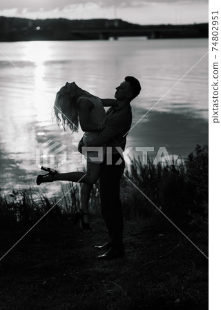 Silouette, loving couple on the lake during sunset. Golden hour 74802951