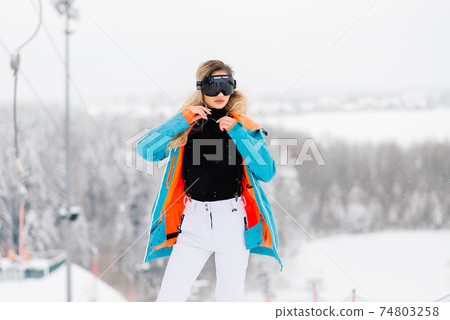 Young sporty woman in winter with snowboard, glasses Young sporty woman in winter with snowboard, glasses 74803258