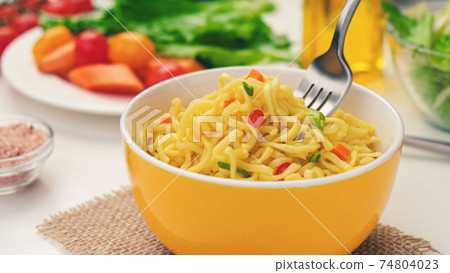 Instant noodles with fork, served with vegetables and herbs Instant noodles with fork, served with vegetables and herbs 74804023