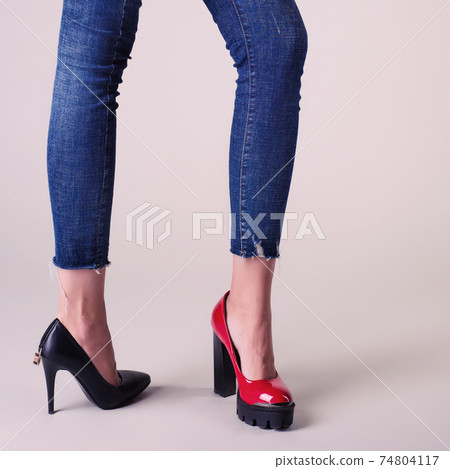Woman legs in summer shoes isolated over neutral background. select your pair concept - red or black 74804117
