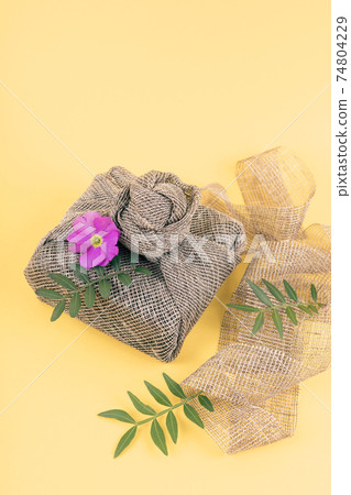 Furoshiki gifts with fresh flowers and leaves. 74804229