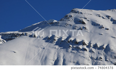 Snow covered rock layers. Mount Mittaghorn. 74804378