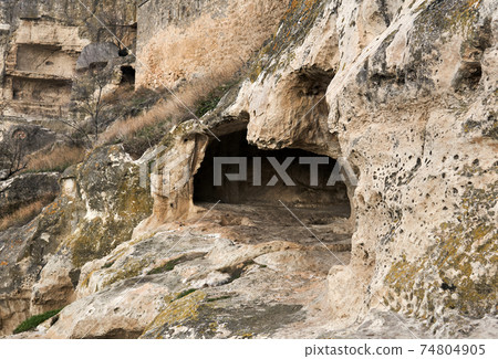 view of the ruins of an ancient cave city-fortress on a rocky slope view of the ruins of an ancient cave city-fortress on a rocky slope 74804905