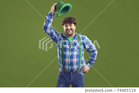 Portrait of happy smiling chubby Irish guy in green hat having fun on Saint Patrick's Day Portrait of happy smiling chubby Irish guy in green hat having fun on Saint Patrick's Day 74805119