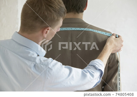Male Tailor Measuring Customer's Suit Male Tailor Measuring Customer's Suit 74805408