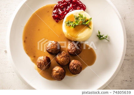 Top view of a plate with Swedish meatballs in sauce with mashed potatoes and cranberry sauce 74805639