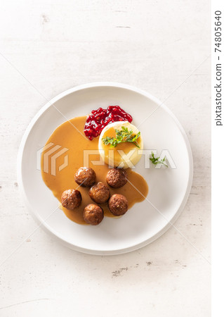 Top view of a plate with Swedish meatballs in sauce with mashed potatoes and cranberry sauce Top view of a plate with Swedish meatballs in sauce with mashed potatoes and cranberry sauce 74805640