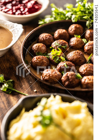 Swedish food Kottbullar meatballs, served in a pan with mashed potatoes, parsley and cranberry sauce 74805641