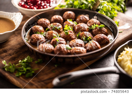 Swedish meatballs, kottbullar, in a pan topped with fresh parsley 74805643