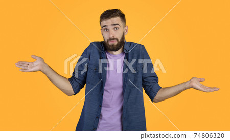 I don't know. Handsome Caucasian guy shrugging shoulders, feeling puzzled or uncertain on orange studio background I don't know. Handsome Caucasian guy shrugging shoulders, feeling puzzled or uncertain on orange studio background 74806320
