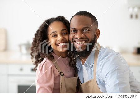 Cheerful black father and daughter posing in kitchen 74806397