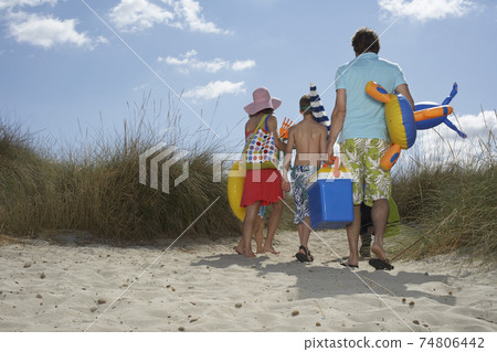 Rear View Of Family With Beach Accessories On Shore 74806442