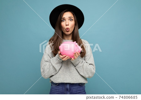 Portrait of shocked amazed funny young pretty charming brunette woman wearing stylish gray sweater 74806685