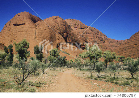 Dirt track leading towards rock formation 74806797