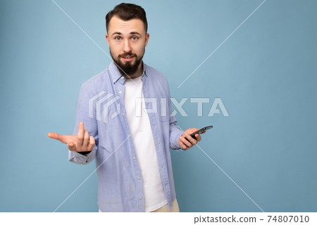 Closeup photo of Dissatisfied handsome young brunette unshaven man with beard wearing stylish white 74807010