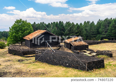 Summer view of lava stone Carpinteri refuge on Mount Etna, Sicily 74807220