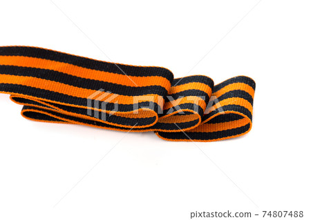 St. George ribbon on a white background. Black orange ribbon close up on a white background. 74807488