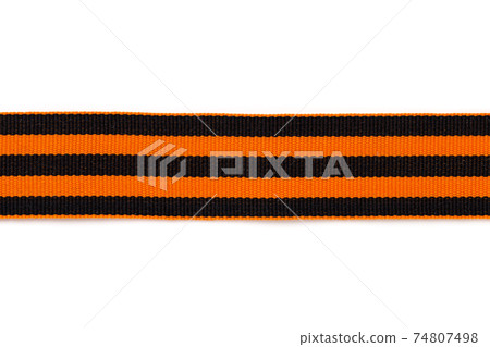 St. George ribbon on a white background. Black orange ribbon close up on a white background. 74807498