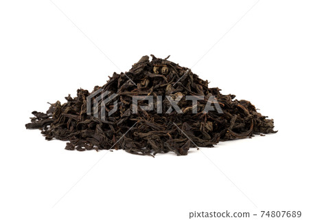Black tea on a white background. A pile of dried tea leaves on a white background. 74807689