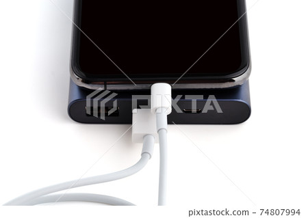 Power bank and smartphone on white background. The smartphone is charging from the power bank. 74807994