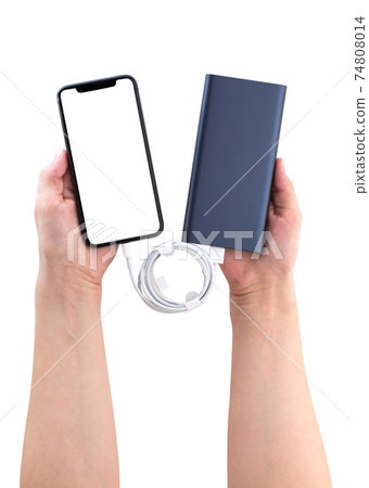 Power bank and smartphone in hands on a white background. The smartphone is charging from the power bank. 74808014