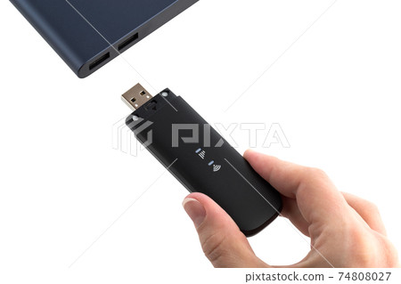 Portable usb modem and hand on a white background. Connect 4g / lte modem to a laptop. 74808027