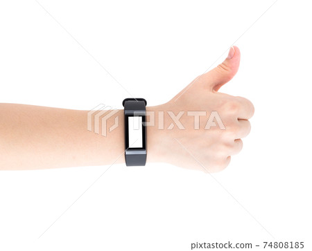 Fitness bracelet on a female hand. Fitness tracker closeup on hand isolated on white background. Thumb raised up. Blank display. Fitness bracelet on a female hand. Fitness tracker closeup on hand isolated on white background. Thumb raised up. Blank display. 74808185