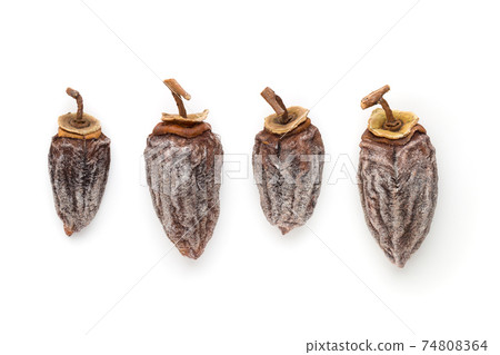Dried persimmon on a white background. Fruits of dried persimmon close-up on a white background. 74808364