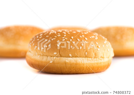 Burger buns on white background. A few buns cut in half close up on a white background. 74808372