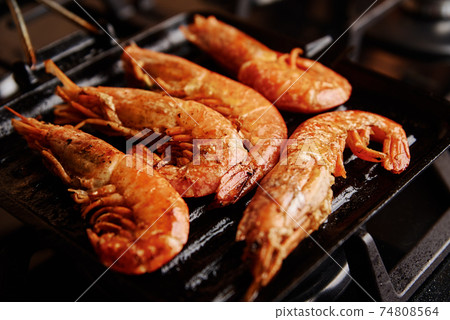 Grilled large shrimps with lemon and spices on the grill pan Grilled large shrimps with lemon and spices on the grill pan 74808564