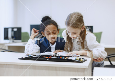 Two beautiful girls paint a notebook. Two beautiful girls paint a notebook. 74809208