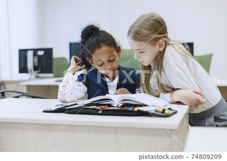 Two beautiful girls paint a notebook. Two beautiful girls paint a notebook. 74809209