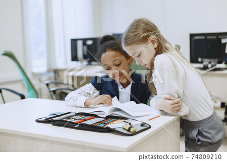 Two beautiful girls paint a notebook. Two beautiful girls paint a notebook. 74809210